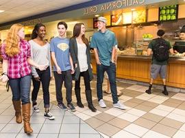 Students talking while waiting for food in the Cafeteria.